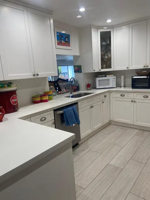 White kitchen with cabinets and counters wiped down and shining